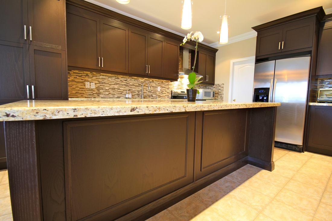 A spacious kitchen with dark colored cabinets
